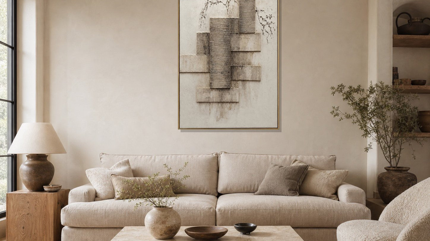 Architectural textured geometric wall art above a beige sofa in a warm neutral living room