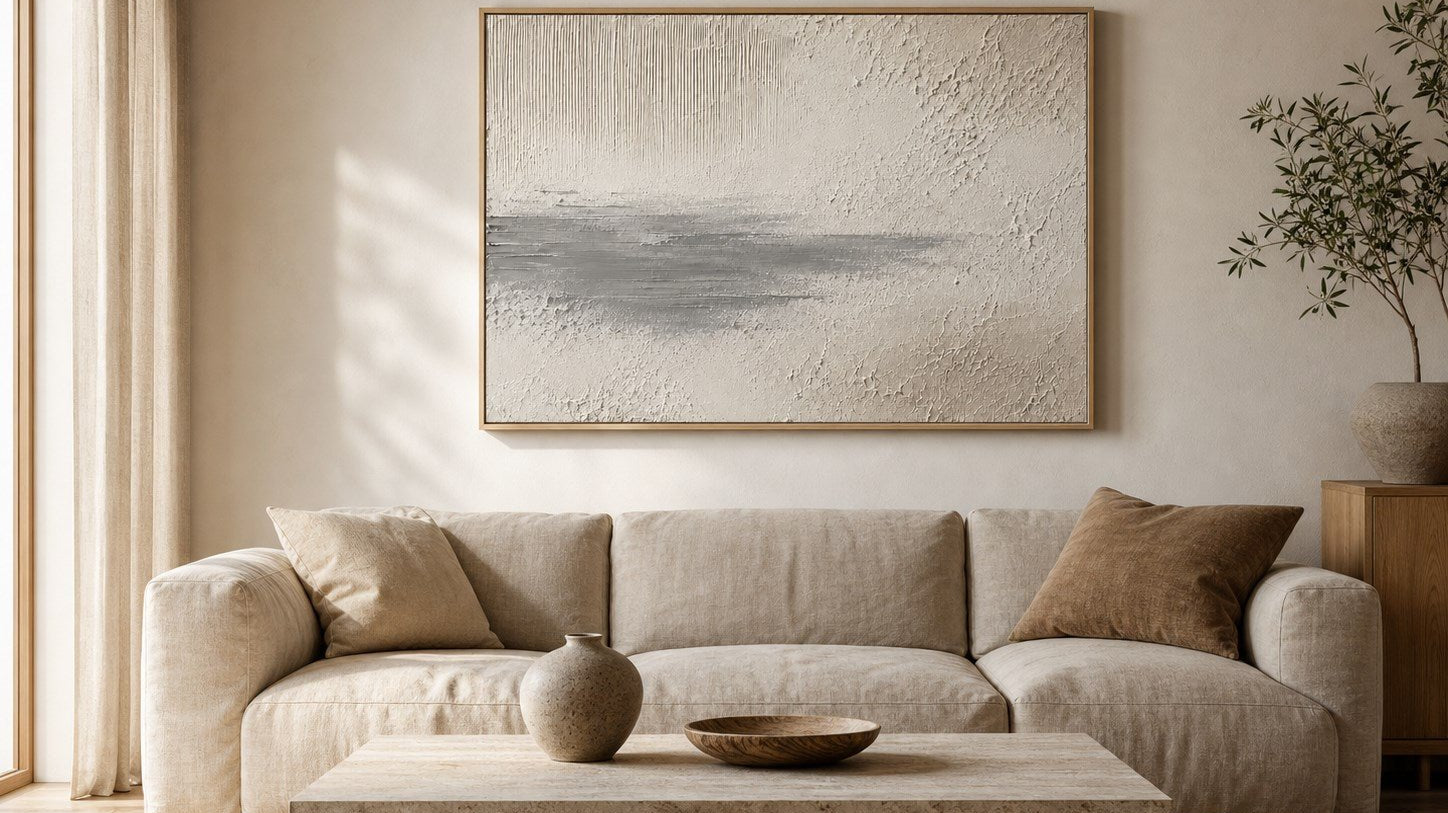 Neutral textured wall art above a linen sofa in an organic modern living room