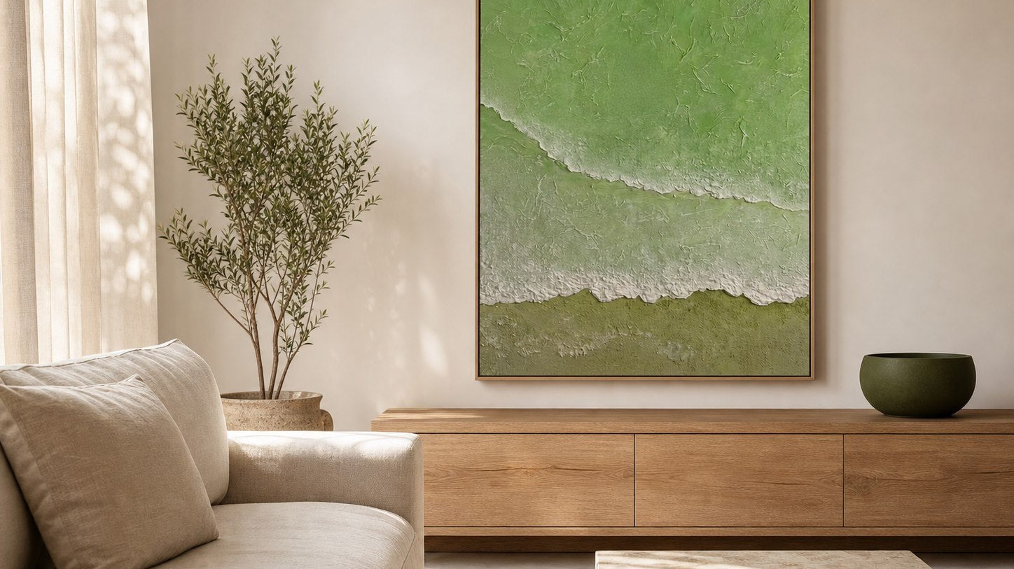 Sage green textured ocean wall art above an oak console in a modern coastal living room