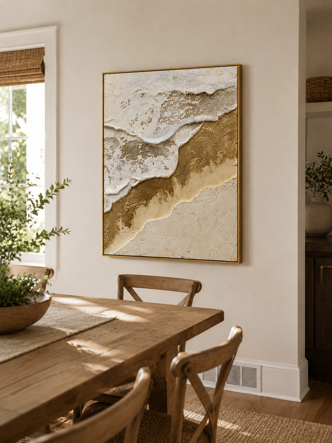 Textured gold ocean wall art displayed in a bright open-plan dining room