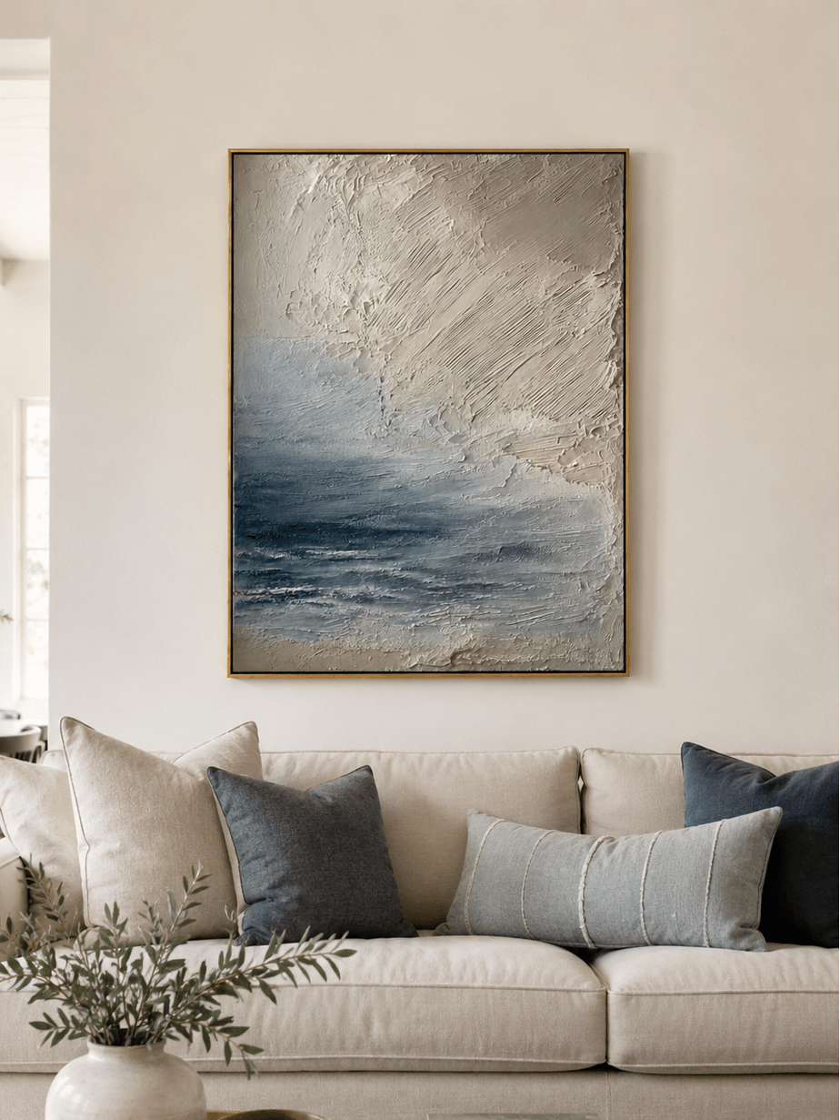 Neutral textured ocean wall art displayed above a beige sofa in an organic modern living room
