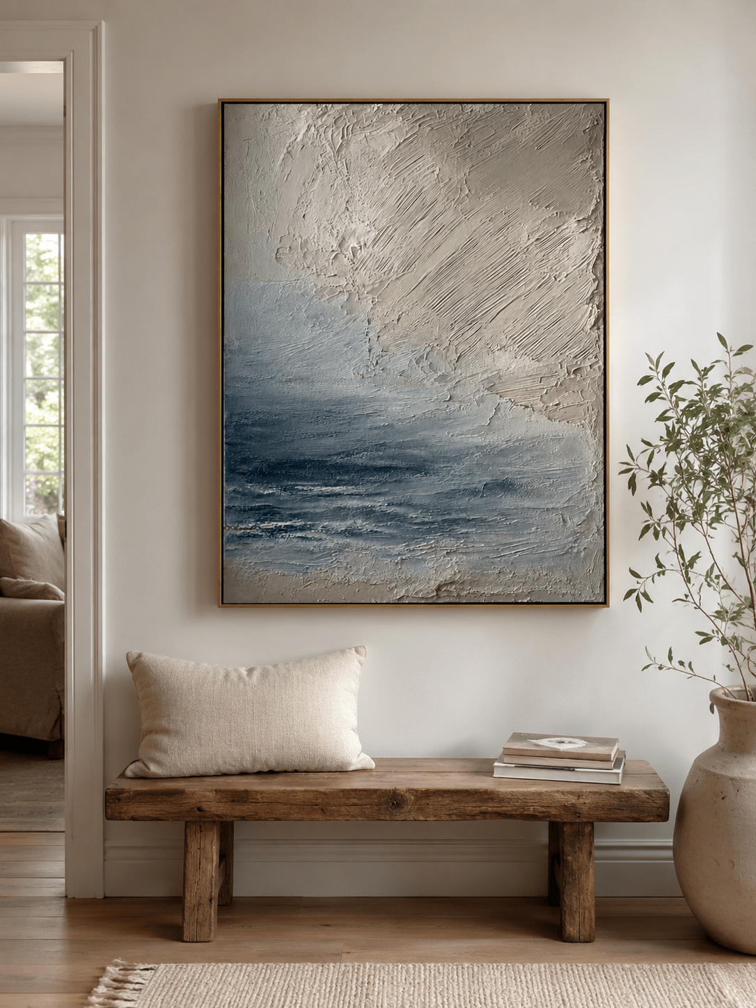 Vertical neutral seascape wall art displayed above a console table in a contemporary entryway
