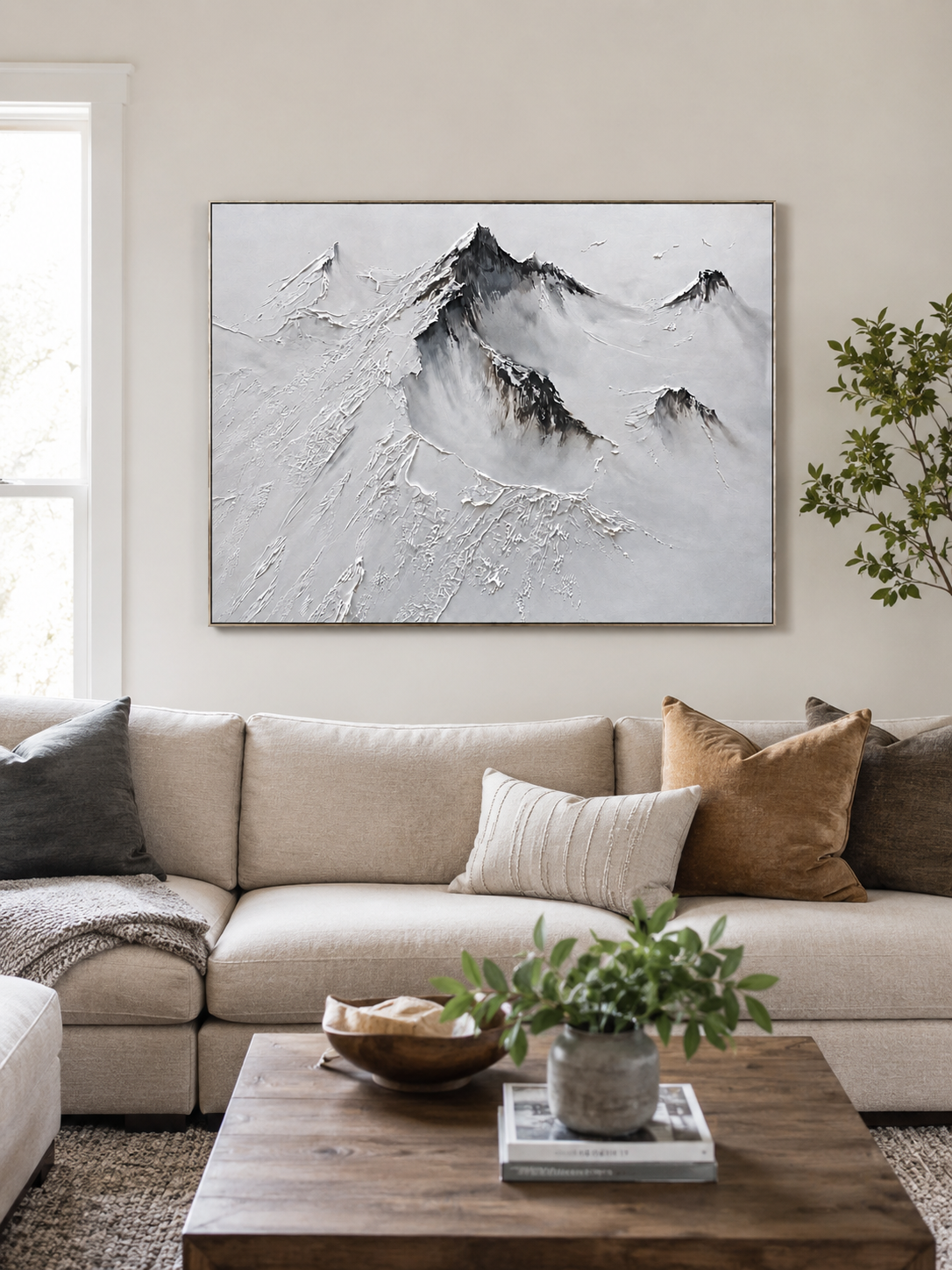 Textured black and white mountain painting above a neutral sofa in a minimalist living room