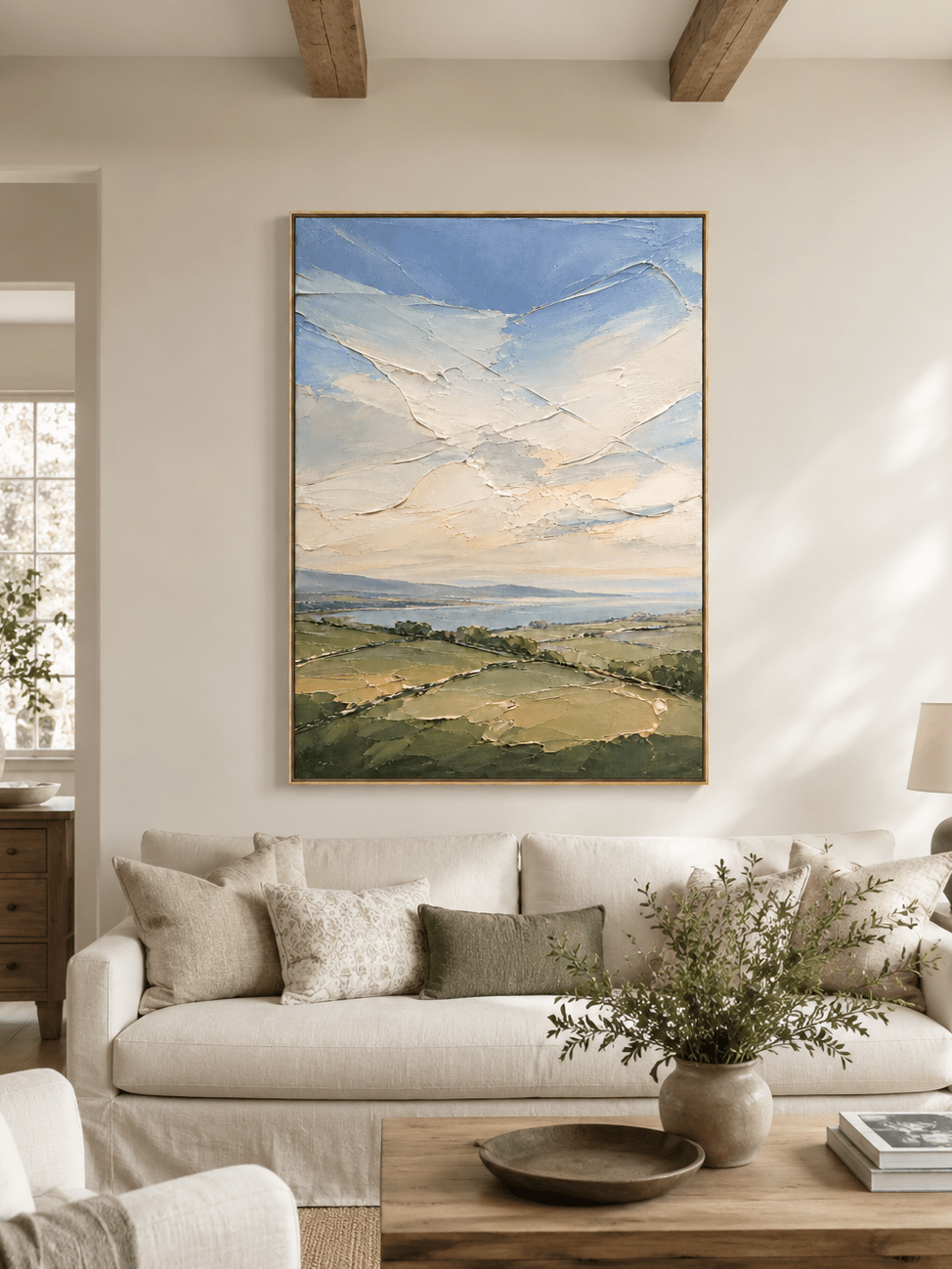 Sage green landscape painting above a cream sofa in an organic modern living room