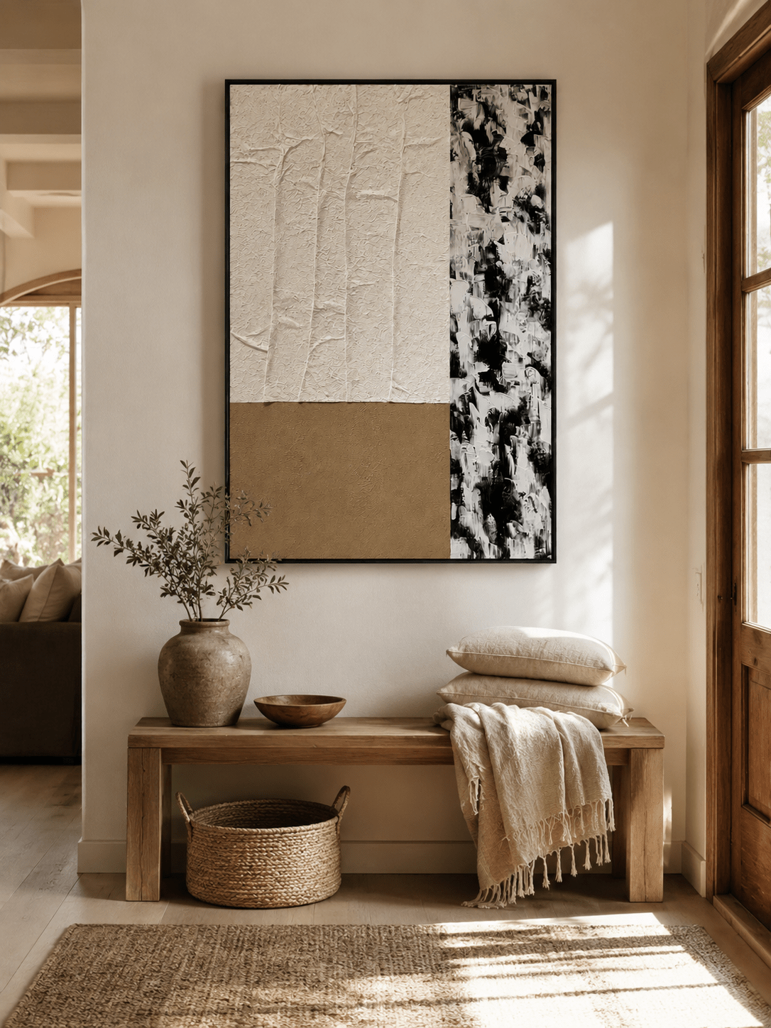 Minimalist black and beige abstract painting displayed above a wood console in an organic modern entryway