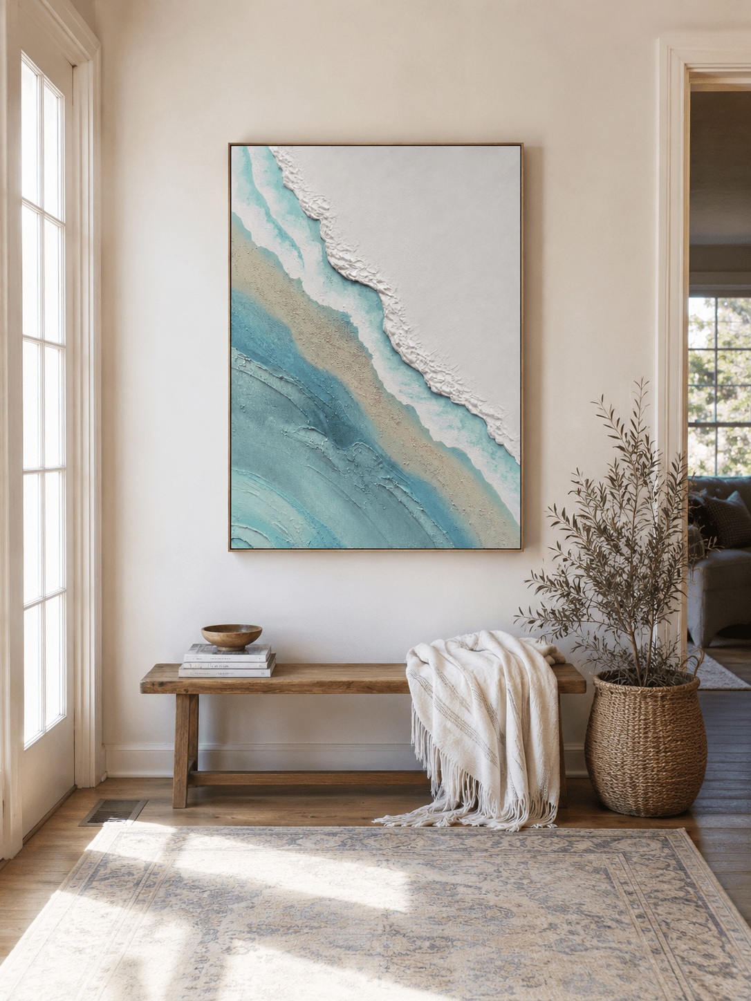 Minimalist coastal wall art above an entryway console in an airy organic modern foyer