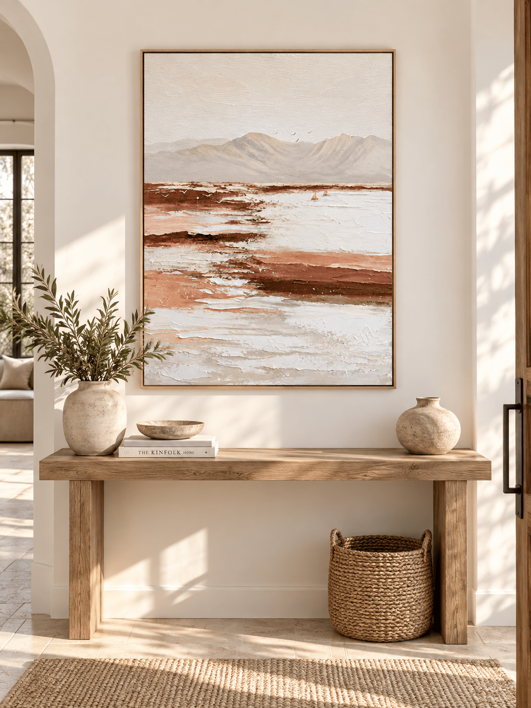 Large vertical earth tone landscape wall art displayed above an entryway console in a wabi-sabi interior