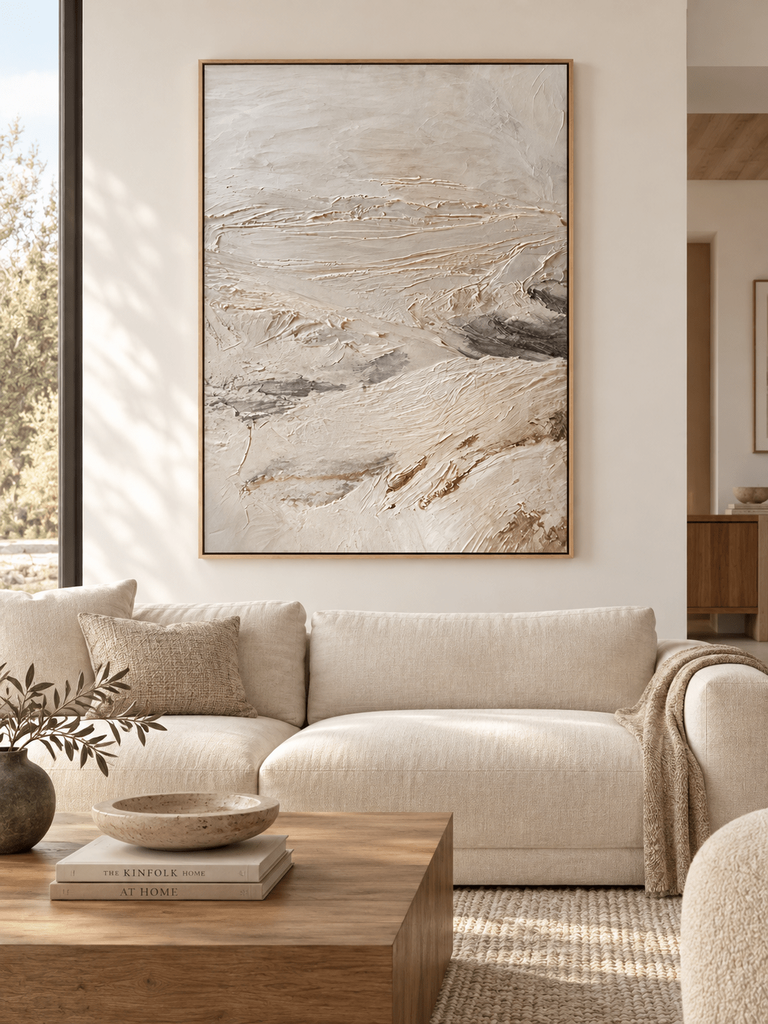 Large neutral textured abstract landscape painting displayed above a modern living room sofa in a minimalist interior