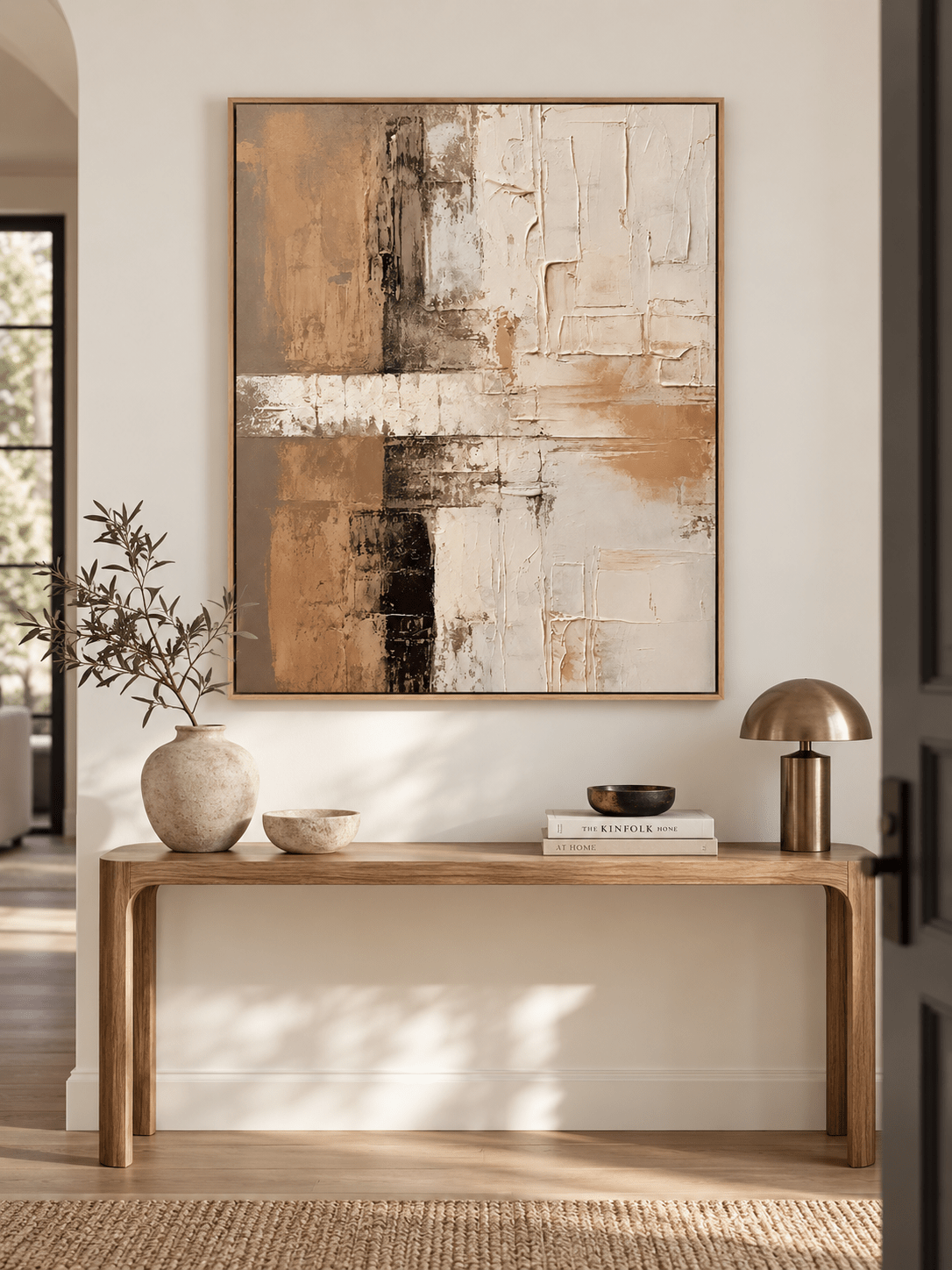 Vertical earth tone textured abstract painting displayed above a console in a contemporary neutral entryway