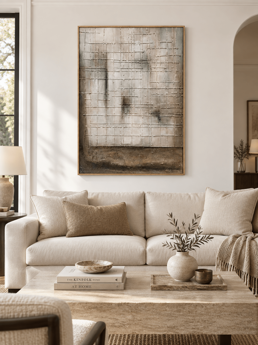 Large neutral textured grid wall art displayed above a sofa in a contemporary warm gray living room