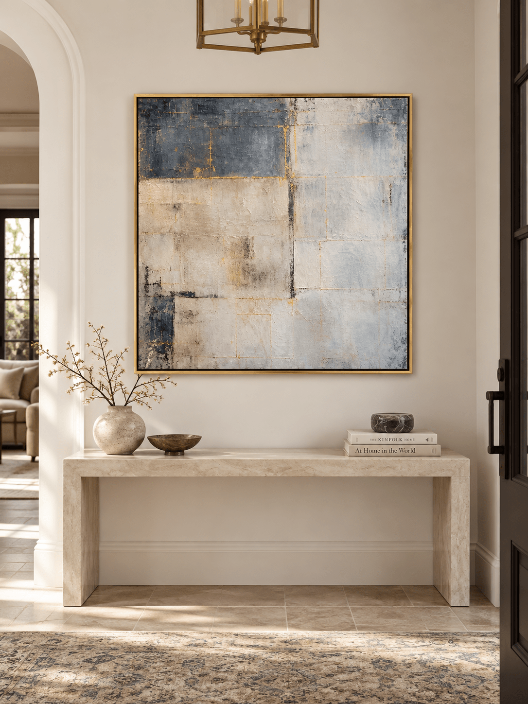 Horizontal blue gray textured abstract painting with subtle golden details displayed above an entryway console