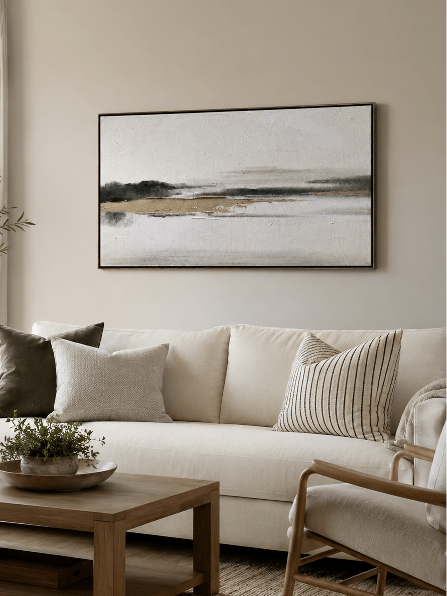 Black and white abstract landscape wall art above a neutral sofa