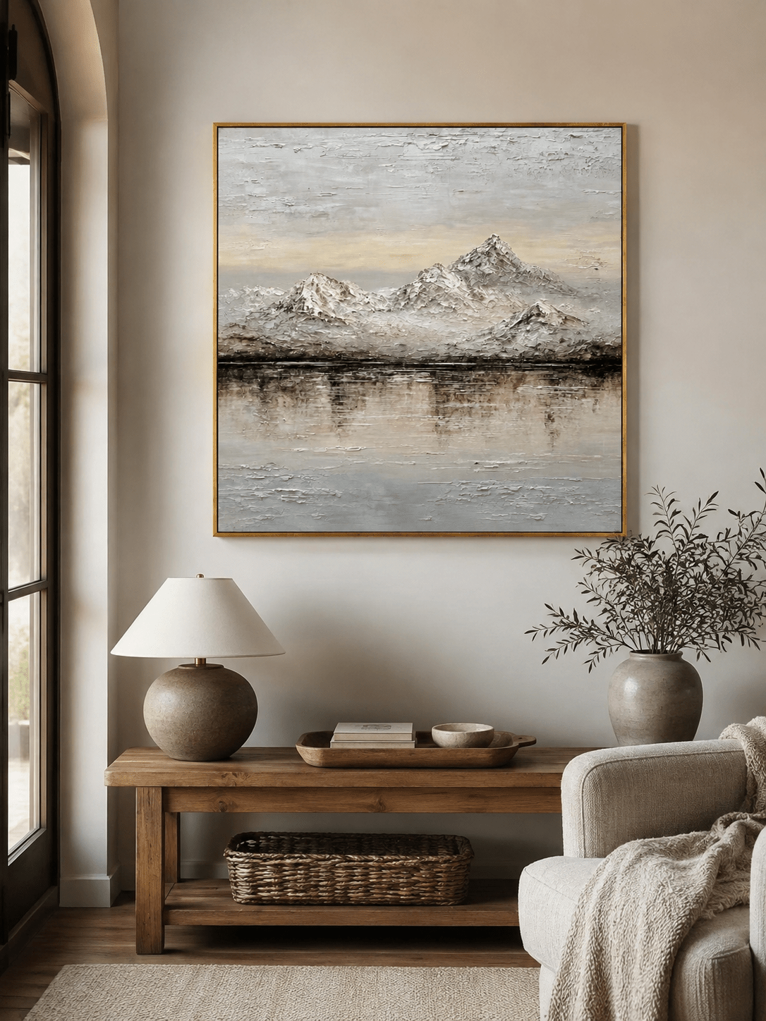 Neutral mountain wall art above an entryway console in a quiet organic modern foyer