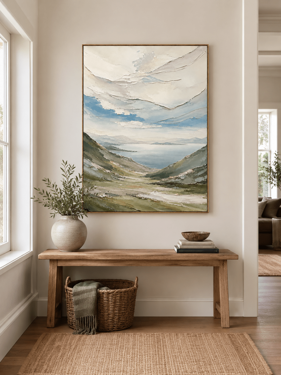 Textured mountain landscape wall art above an entryway console in an organic modern foyer