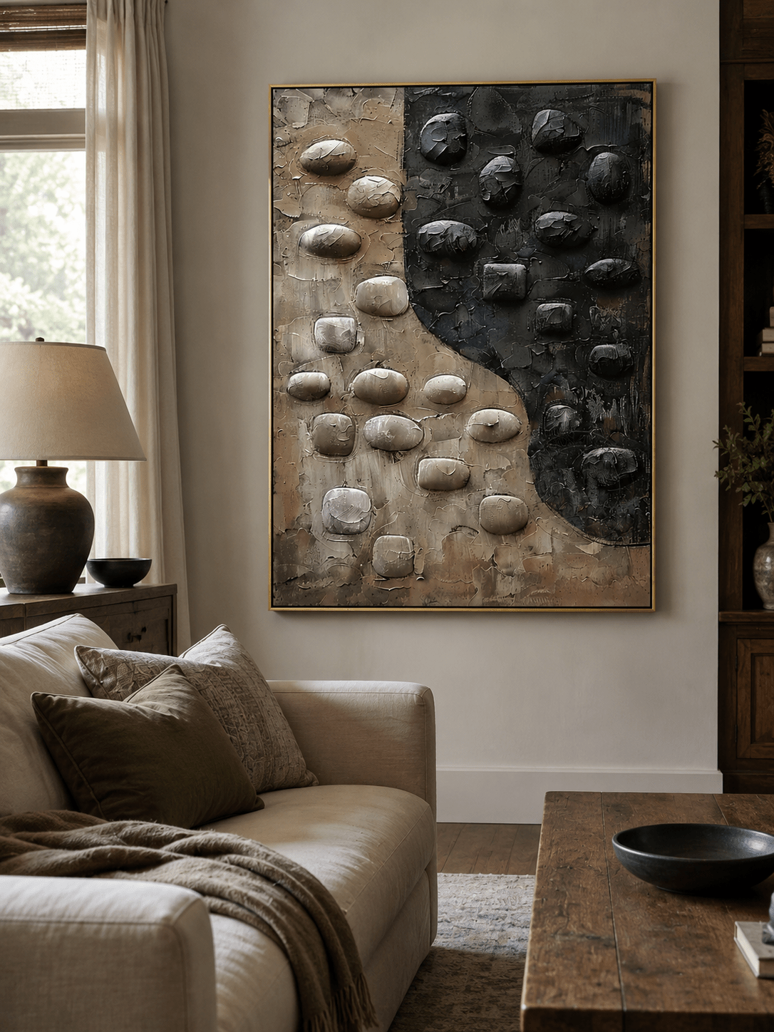 Black and beige textured wall art above a cream sofa in an organic modern living room