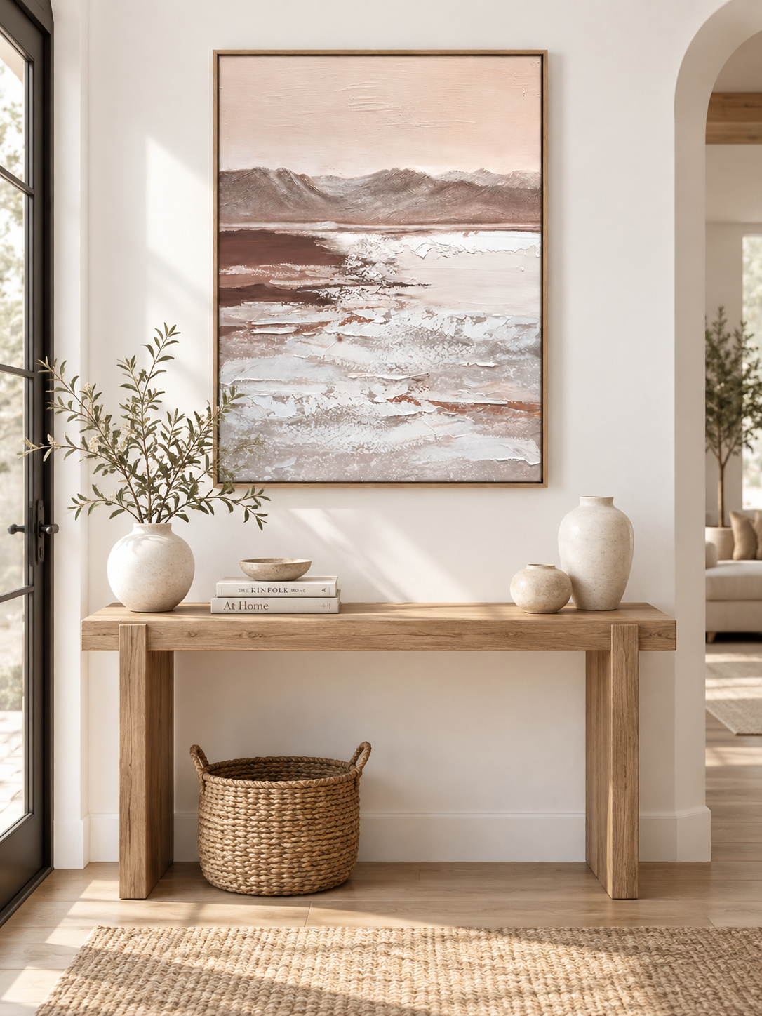 Large vertical textured mountain wall art displayed above an entryway console in a wabi-sabi interior
