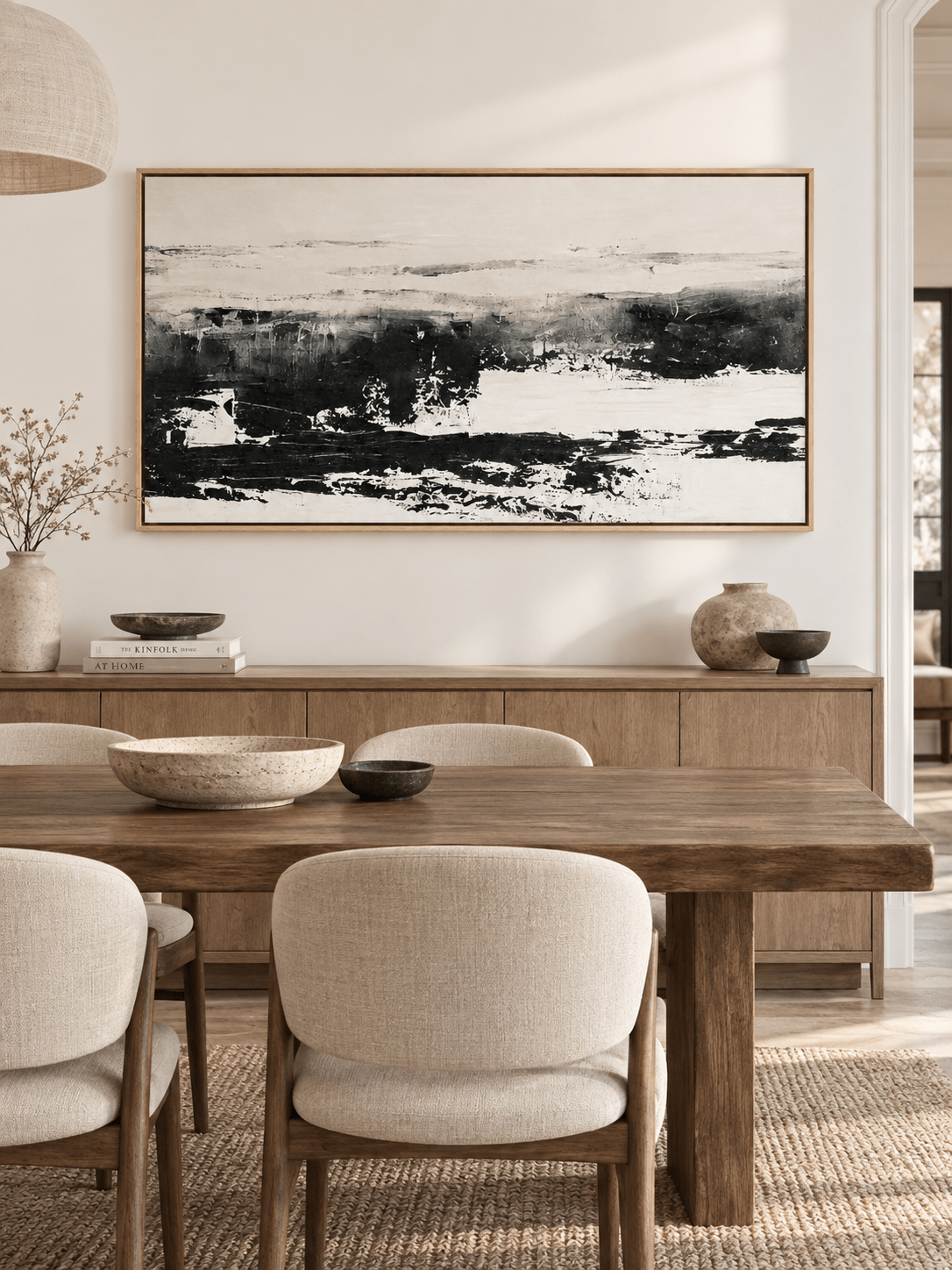 Large horizontal black and white abstract painting displayed in a modern open-plan dining room