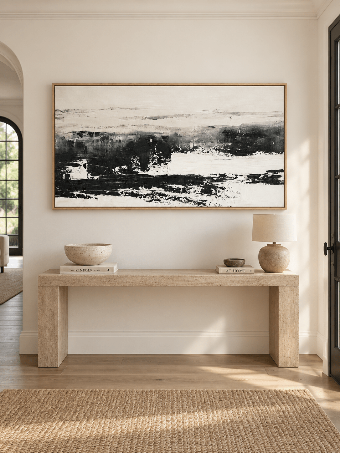 Minimalist black and white abstract wall art displayed above a long console in a contemporary entryway