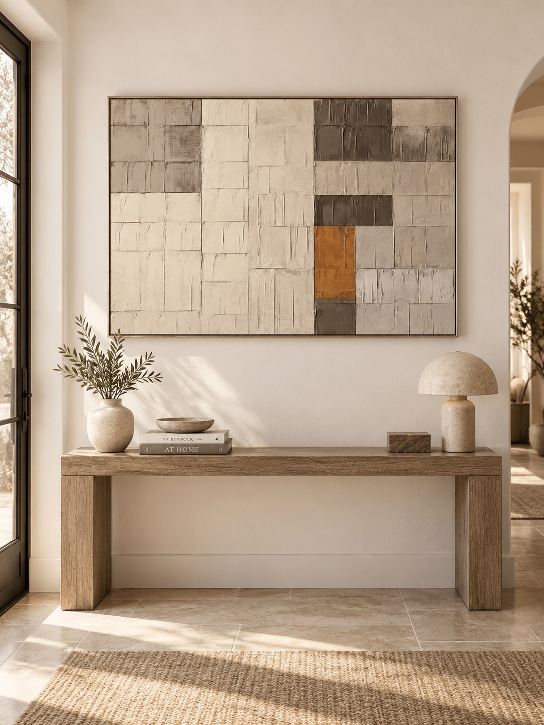 Horizontal greige and ochre geometric painting displayed above a console in a modern organic entryway