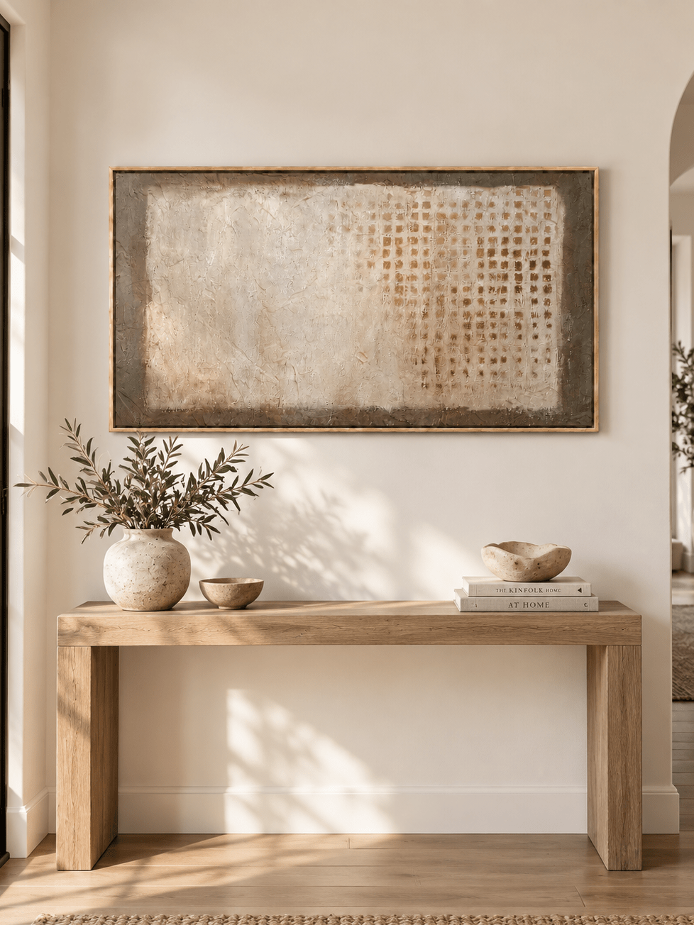 Horizontal neutral abstract painting with a distressed brown grid displayed above a console in a contemporary entryway