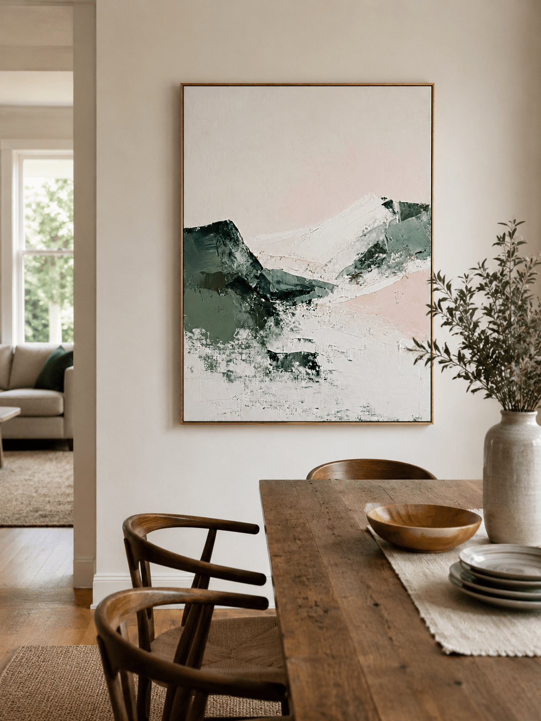 Abstract sage green landscape painting displayed in a warm open-plan dining room