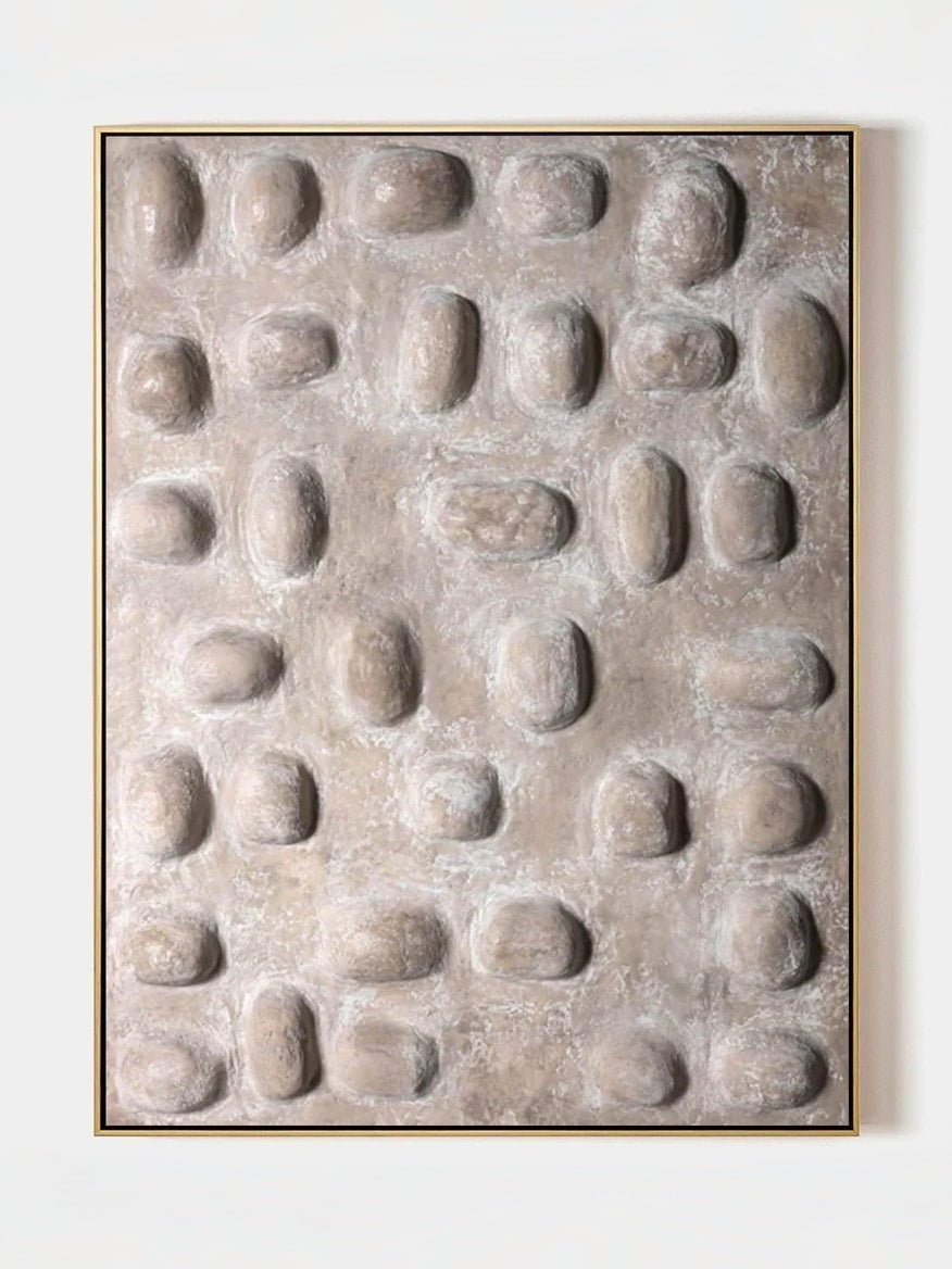 Close-up of hand-painted 3D relief wall art, featuring raised oval stone-like textures in warm beige plaster on a large canvas for a minimalist bedroom.