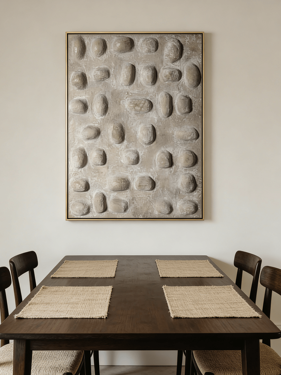 Close-up of hand-painted 3D relief wall art, featuring raised oval stone-like textures in warm beige plaster on a large canvas for a minimalist bedroom.