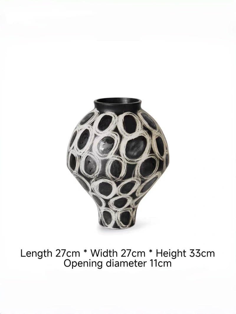 hand-painted black and white abstract ceramic vase with circular patterns, contemporary sculptural vase on a minimalist console.