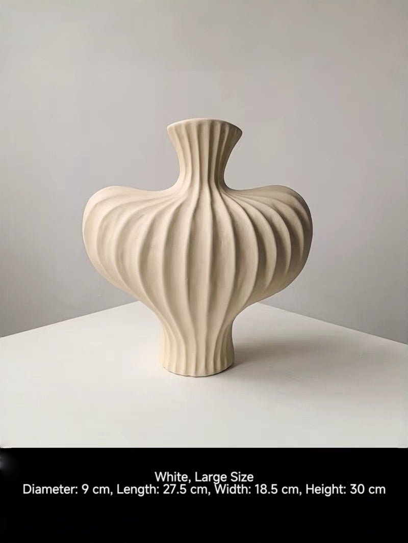 sculptural fluted ceramic vases in black, cream, and terracotta rust, organic heart-shaped silhouette, artistic home decor.