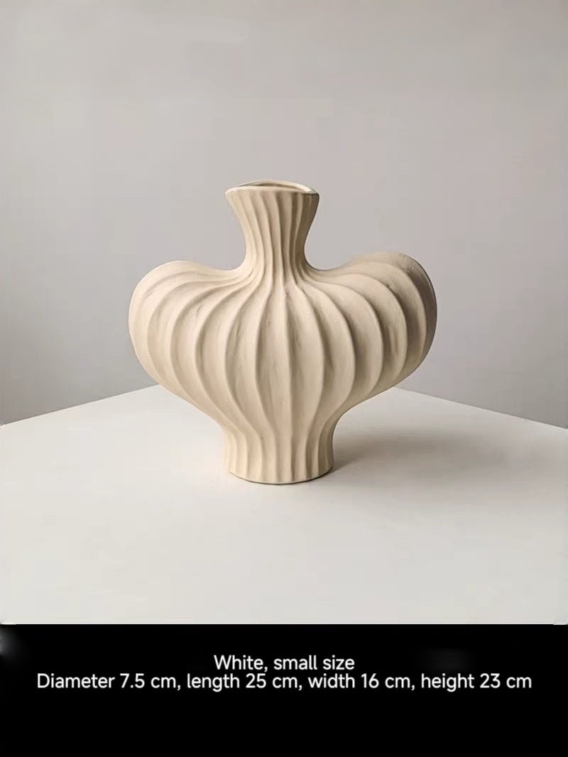 sculptural fluted ceramic vases in black, cream, and terracotta rust, organic heart-shaped silhouette, artistic home decor.