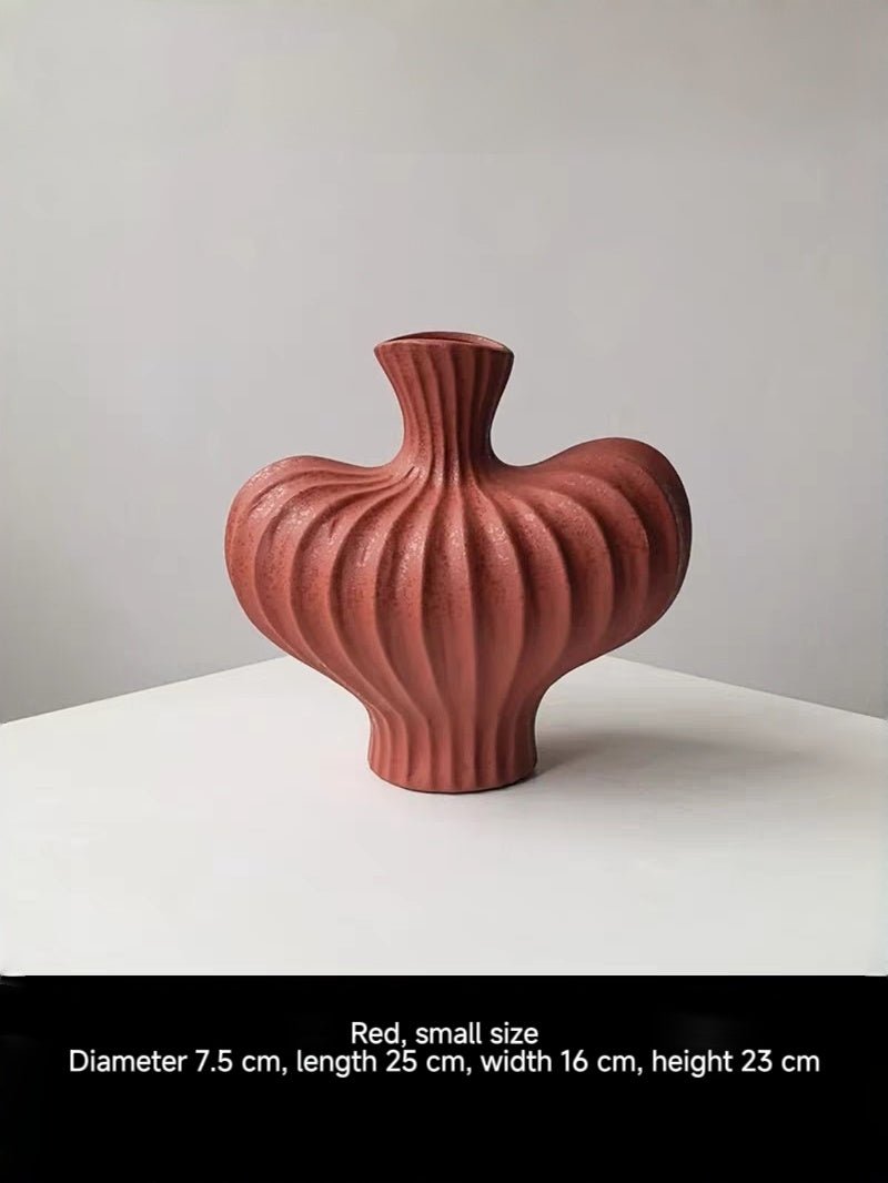 sculptural fluted ceramic vases in black, cream, and terracotta rust, organic heart-shaped silhouette, artistic home decor.