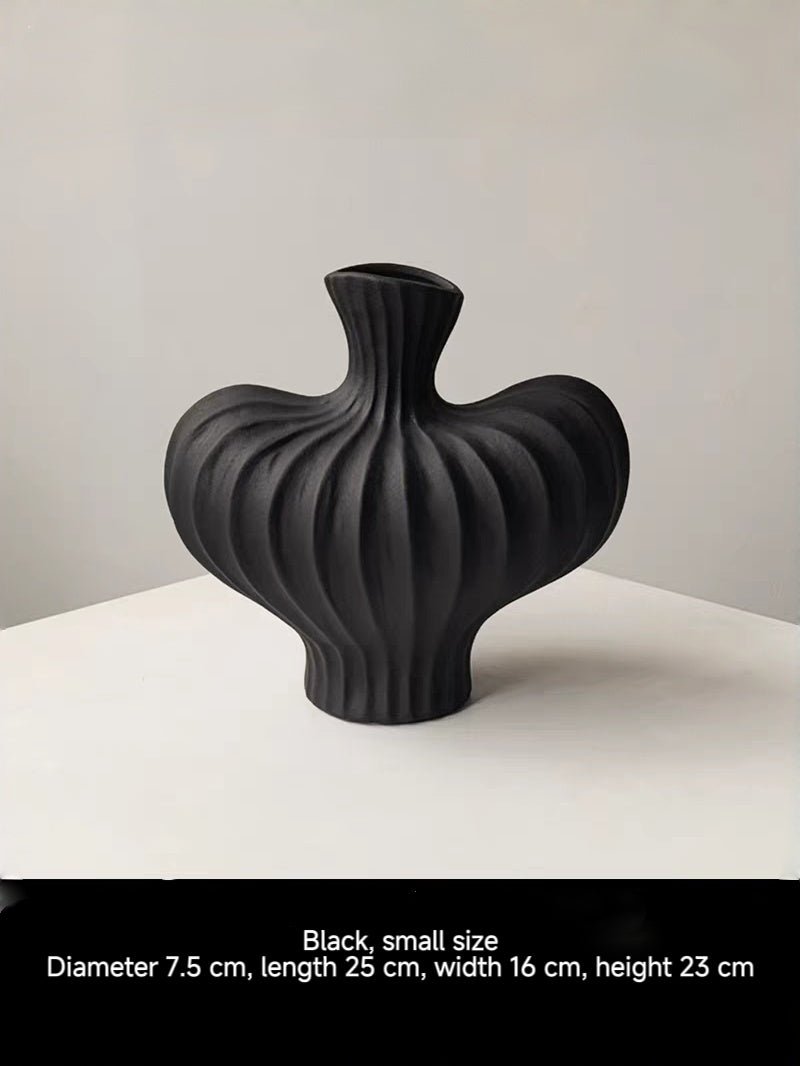 sculptural fluted ceramic vases in black, cream, and terracotta rust, organic heart-shaped silhouette, artistic home decor.