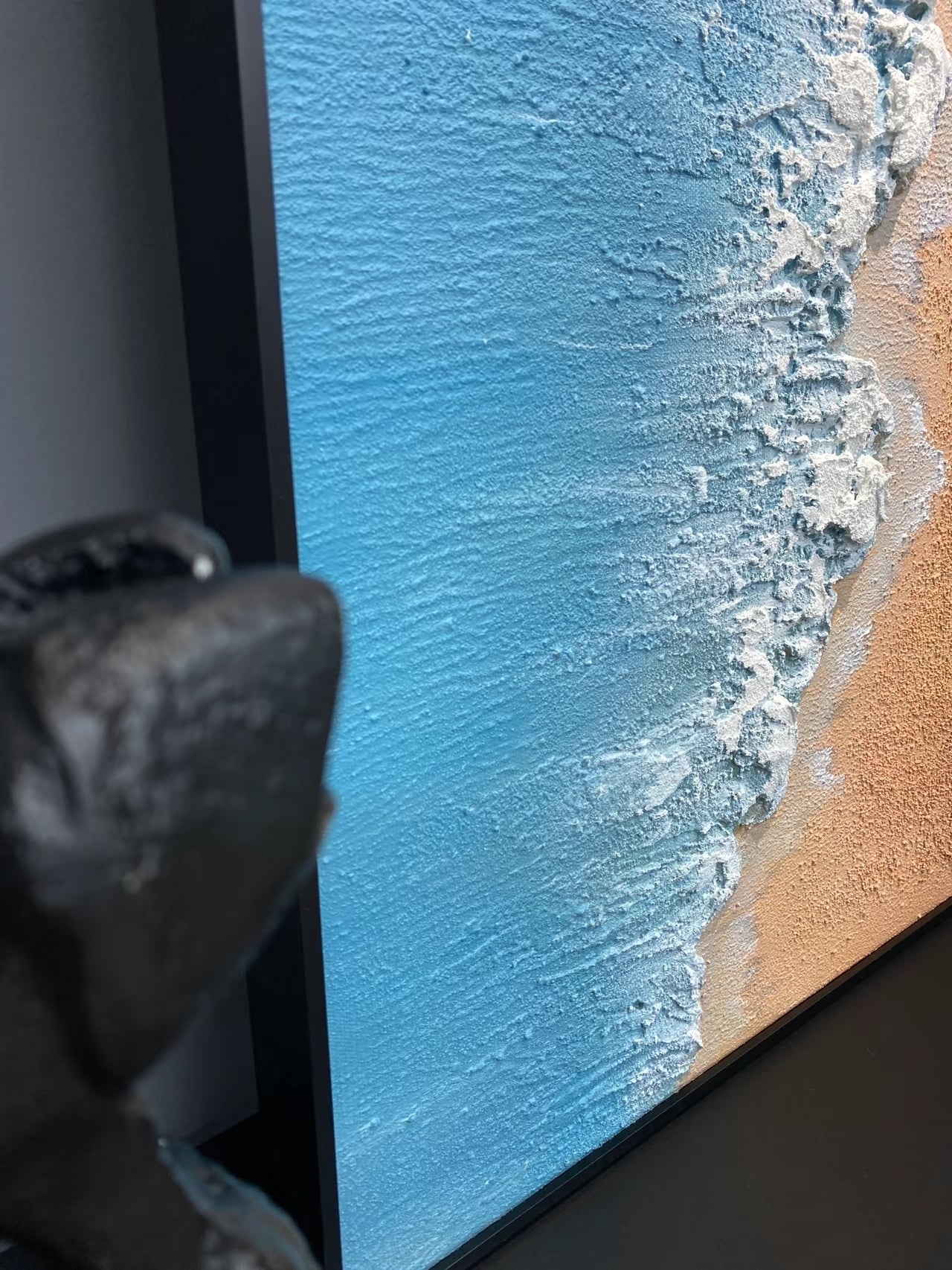 Hand-painted 3D textured aerial view of beach waves with heavy white sculpted foam and granular golden sand texture in a gold frame.