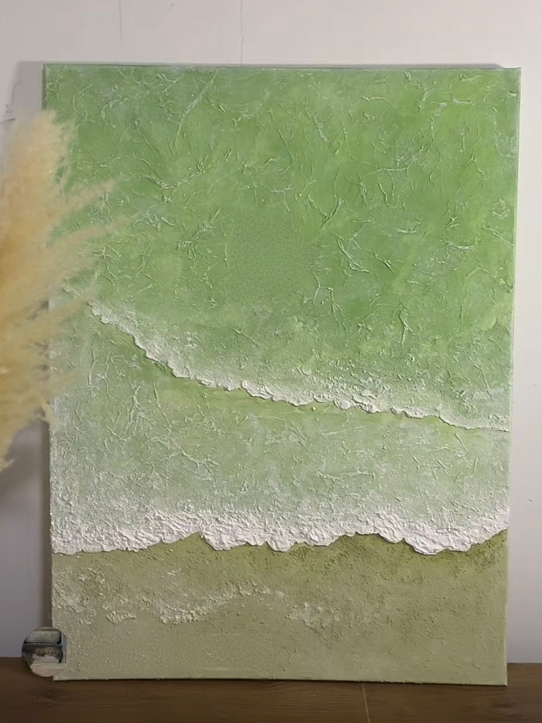 Close-up of 3D hand-painted textured ocean waves in sage green and olive, showing thick white sculpted seafoam ridges on canvas.