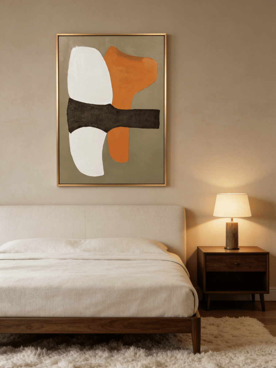 Hand-painted modern organic abstract painting featuring a vibrant orange shape and thick charcoal brushstroke on a sand background in a gold frame.