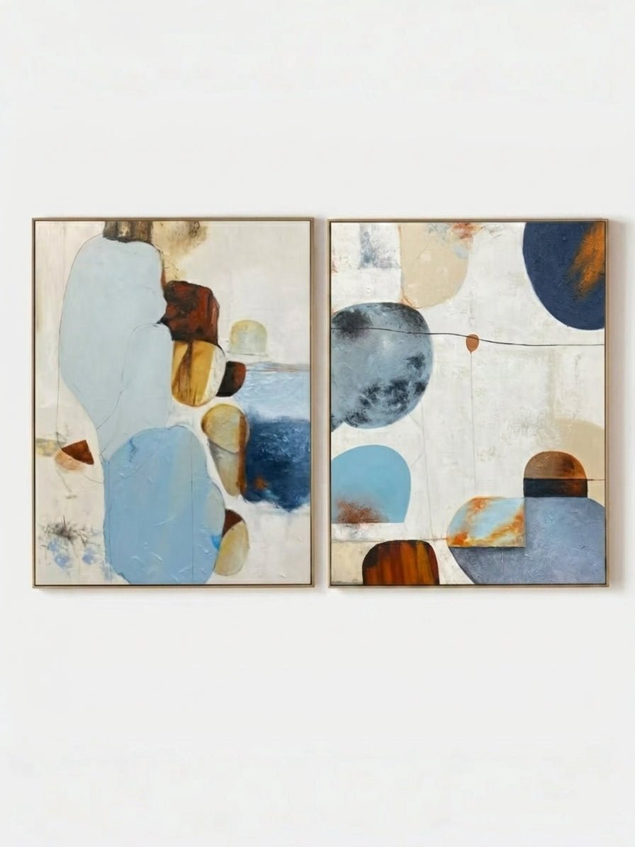 Large 2-piece hand-painted abstract diptych with organic blue and terracotta shapes and heavy texture by Seraphina Rose in a modern coastal living room.