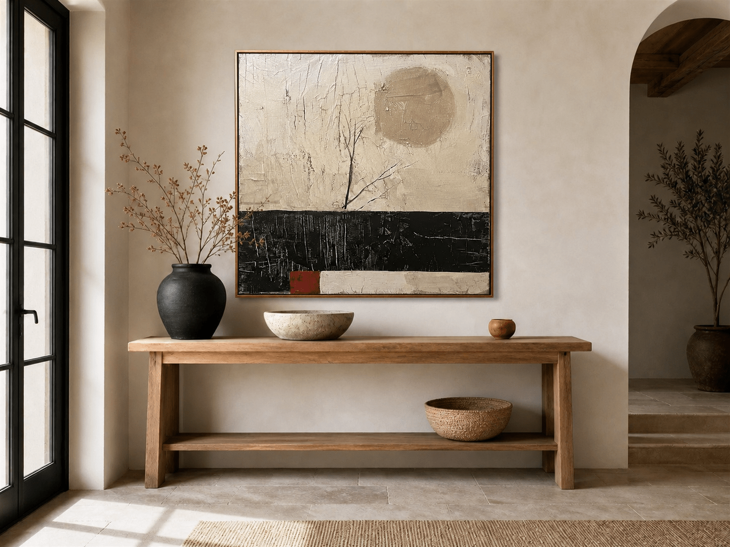 Black and beige abstract wall art above a wood console in a neutral interior