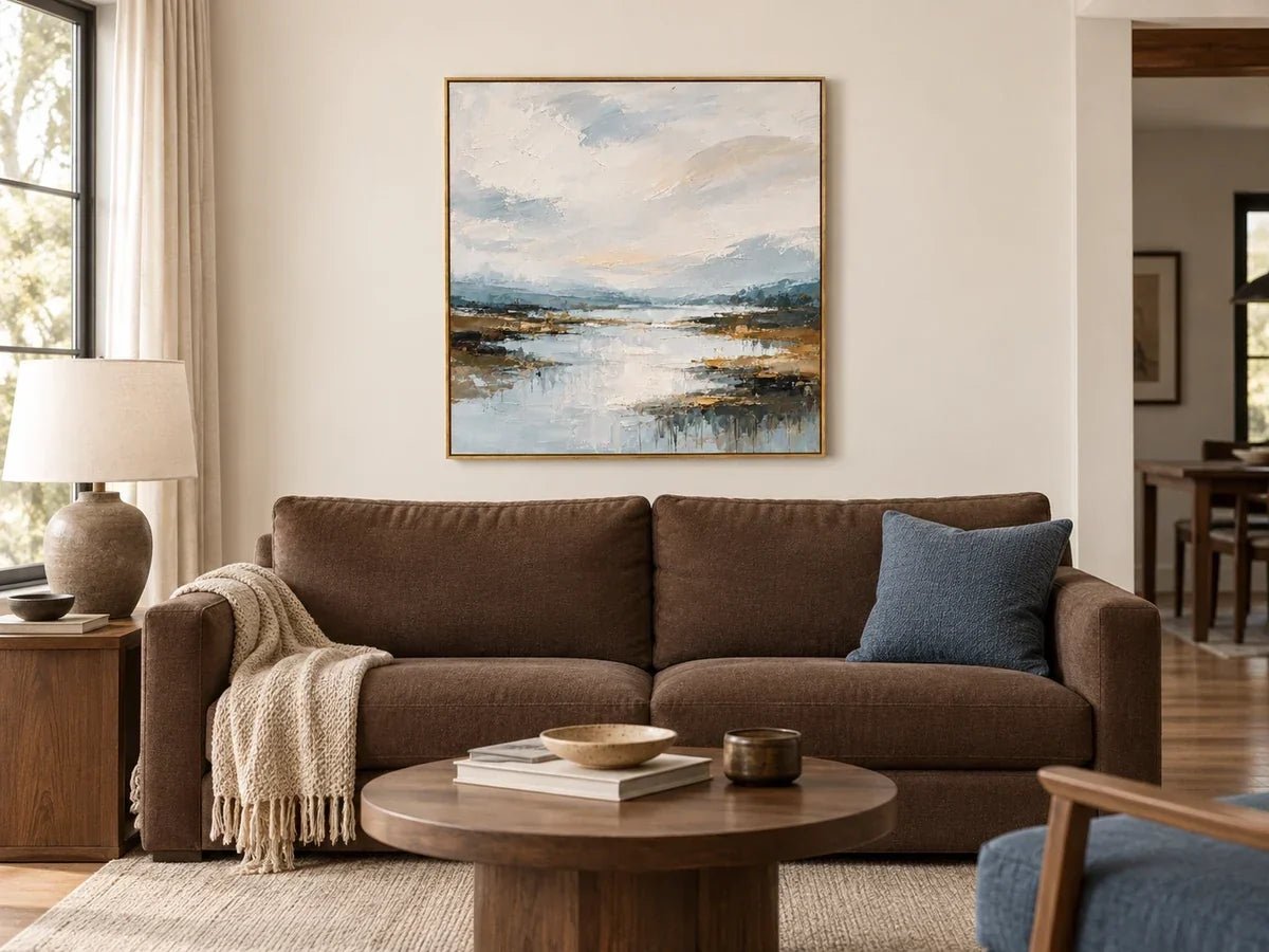 Blue river landscape above a chocolate sofa with walnut furniture