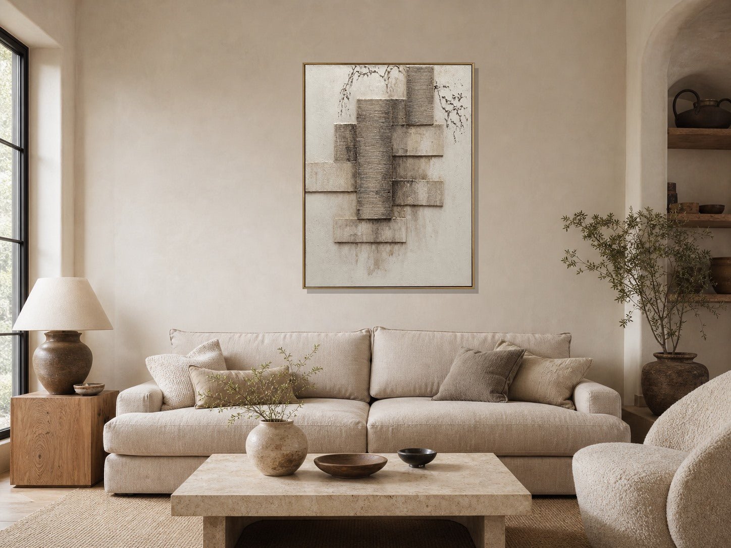Architectural textured geometric wall art above a beige sofa in a warm neutral living room