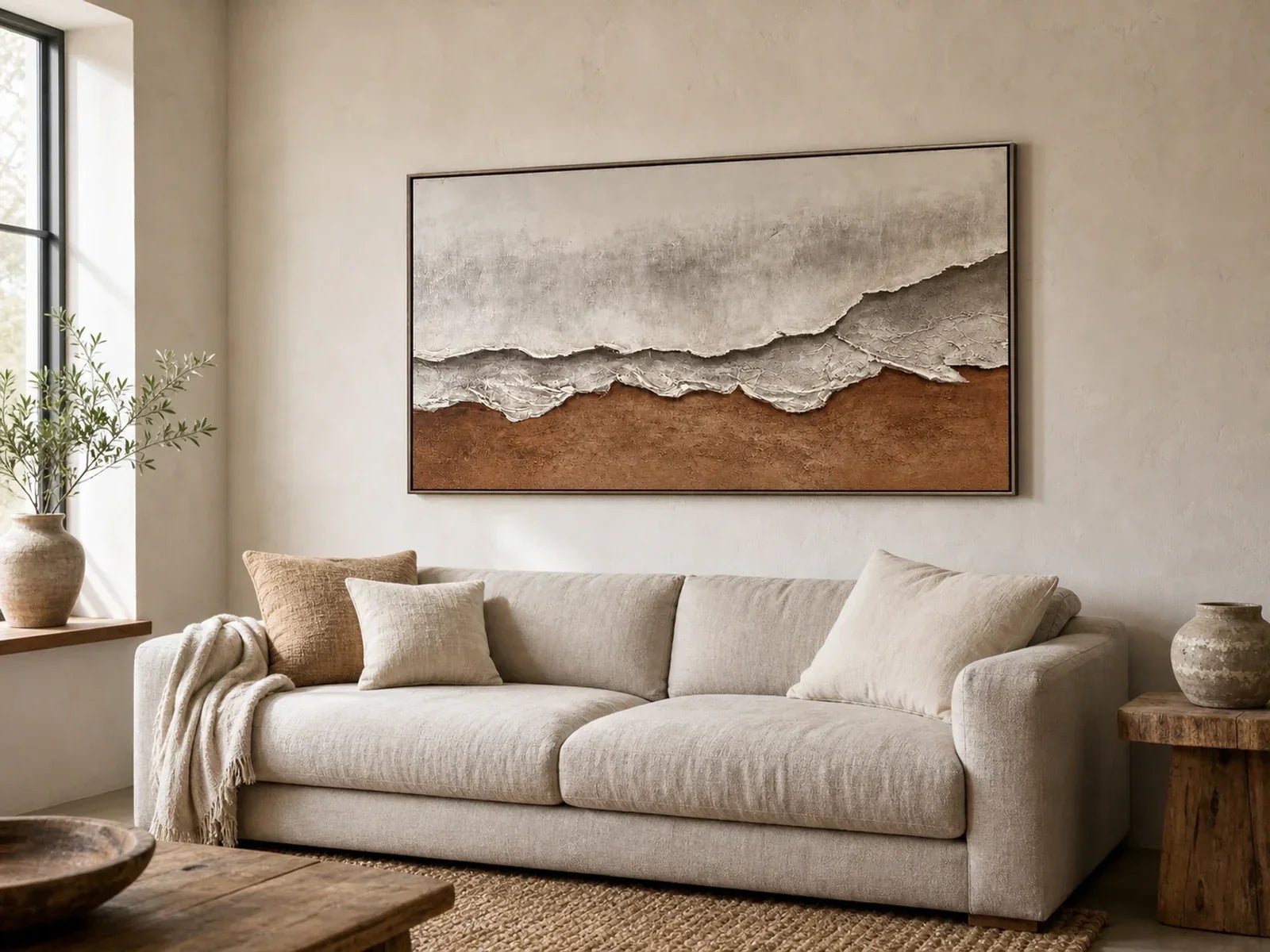 Handmade plaster wall art above a neutral linen sofa in a modern living room
