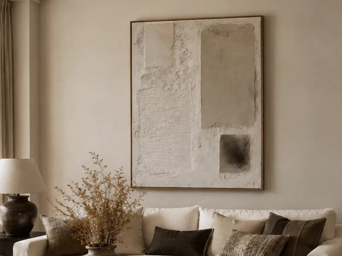 Heavy textured Wabi-Sabi wall art above a cream sofa in a warm neutral living room.