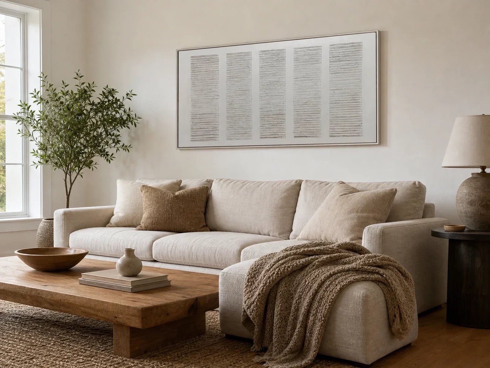 Minimalist panoramic handmade wall art in a floating frame above a neutral living room sofa