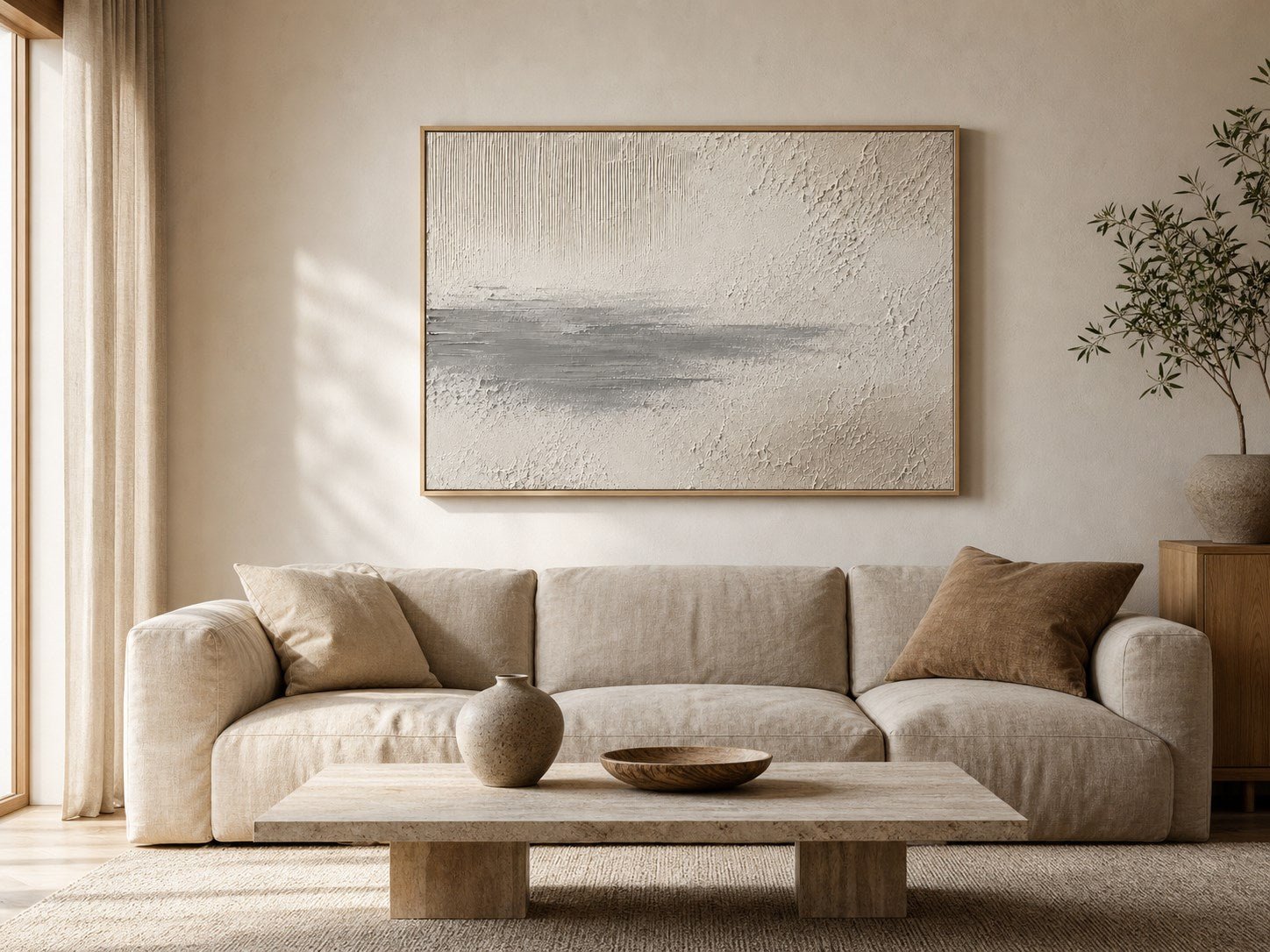 Neutral textured wall art above a linen sofa in an organic modern living room