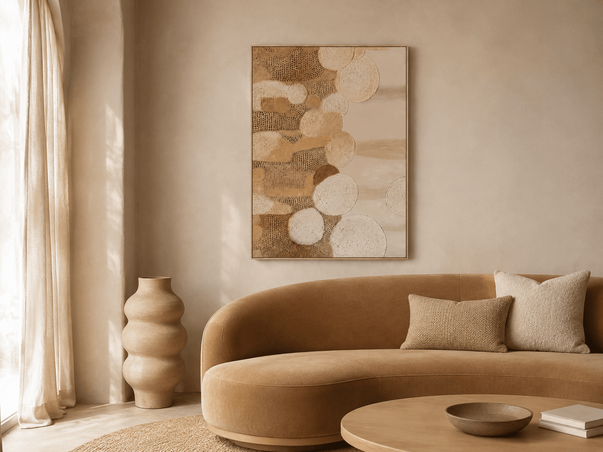 Earthen circles textured painting displayed above a curved camel sofa