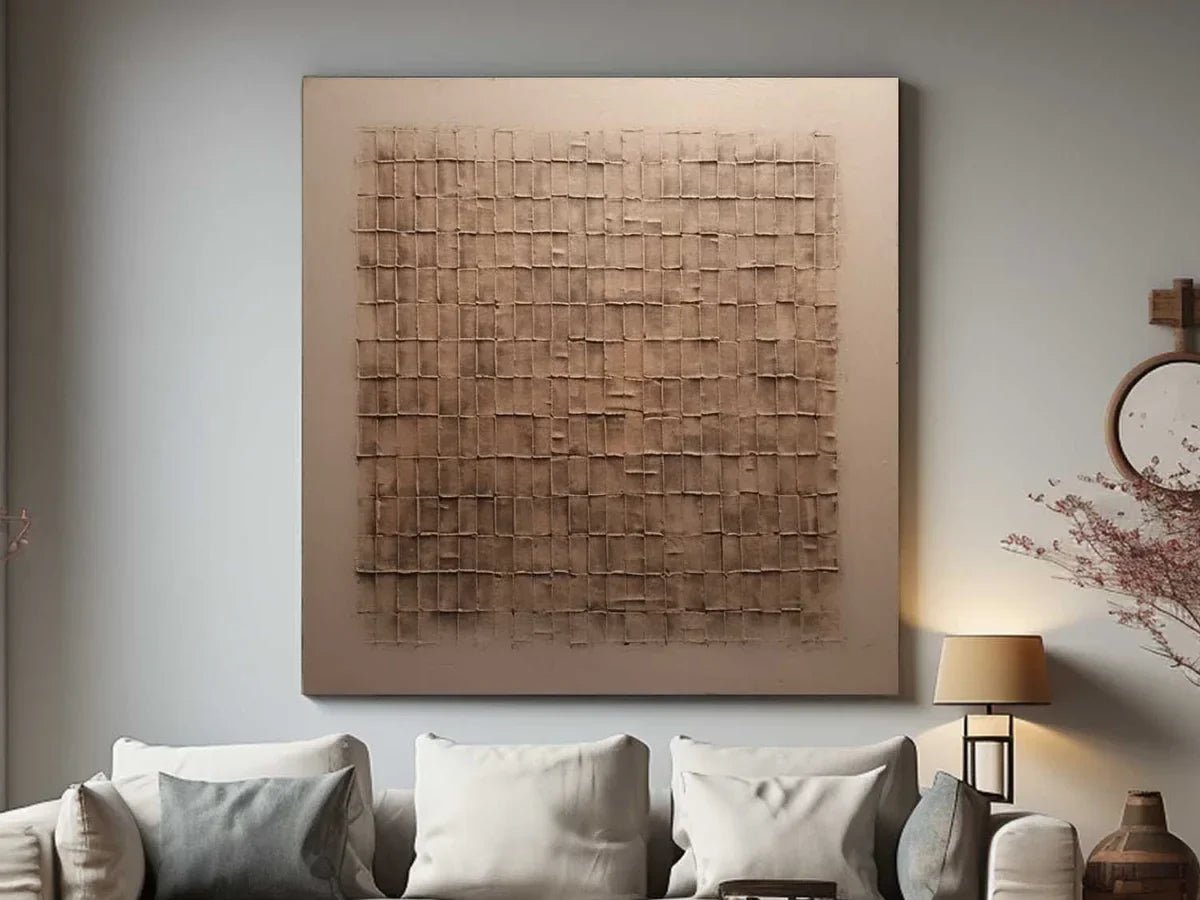 Beige and bronze Wabi-Sabi textured wall art displayed above a cream sofa in a neutral living room.
