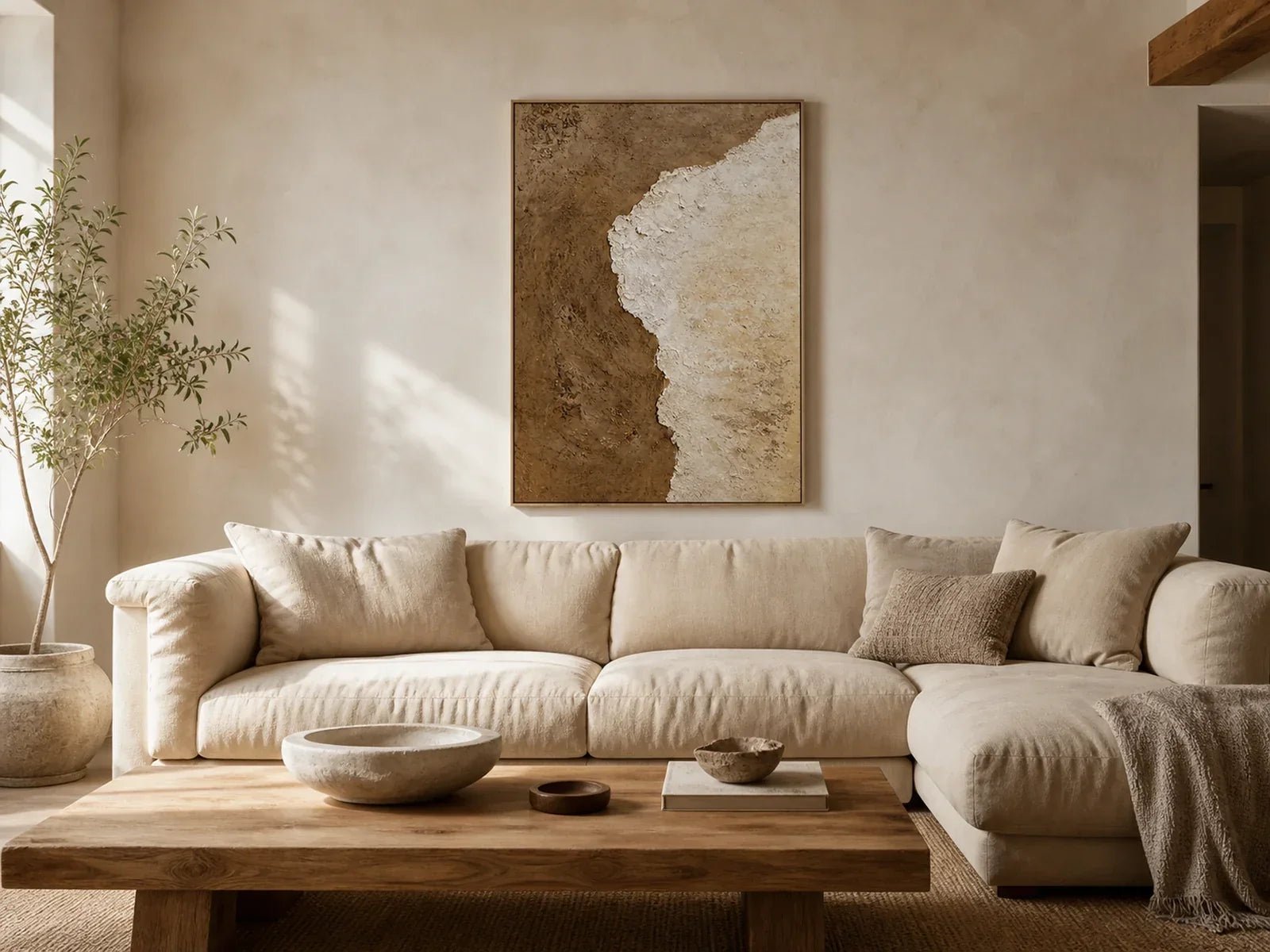Brown and ivory earth tone wall art above a modern beige sofa