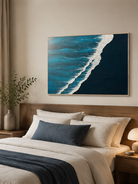 Blue textured ocean wall art displayed above the bed in a calm contemporary bedroom