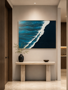 Modern teal ocean wave painting displayed above a wide wood console in a contemporary entryway