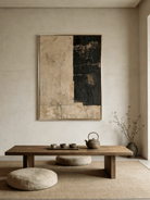 Large vertical hand-painted abstract painting with black and beige color blocks and heavy texture by Akari Kobayashi in a modern living room.