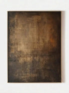 Close-up of vertical hand-painted 3D textured abstract painting with amber, brown, and charcoal impasto layers by Akari Kobayashi in a gold frame.
